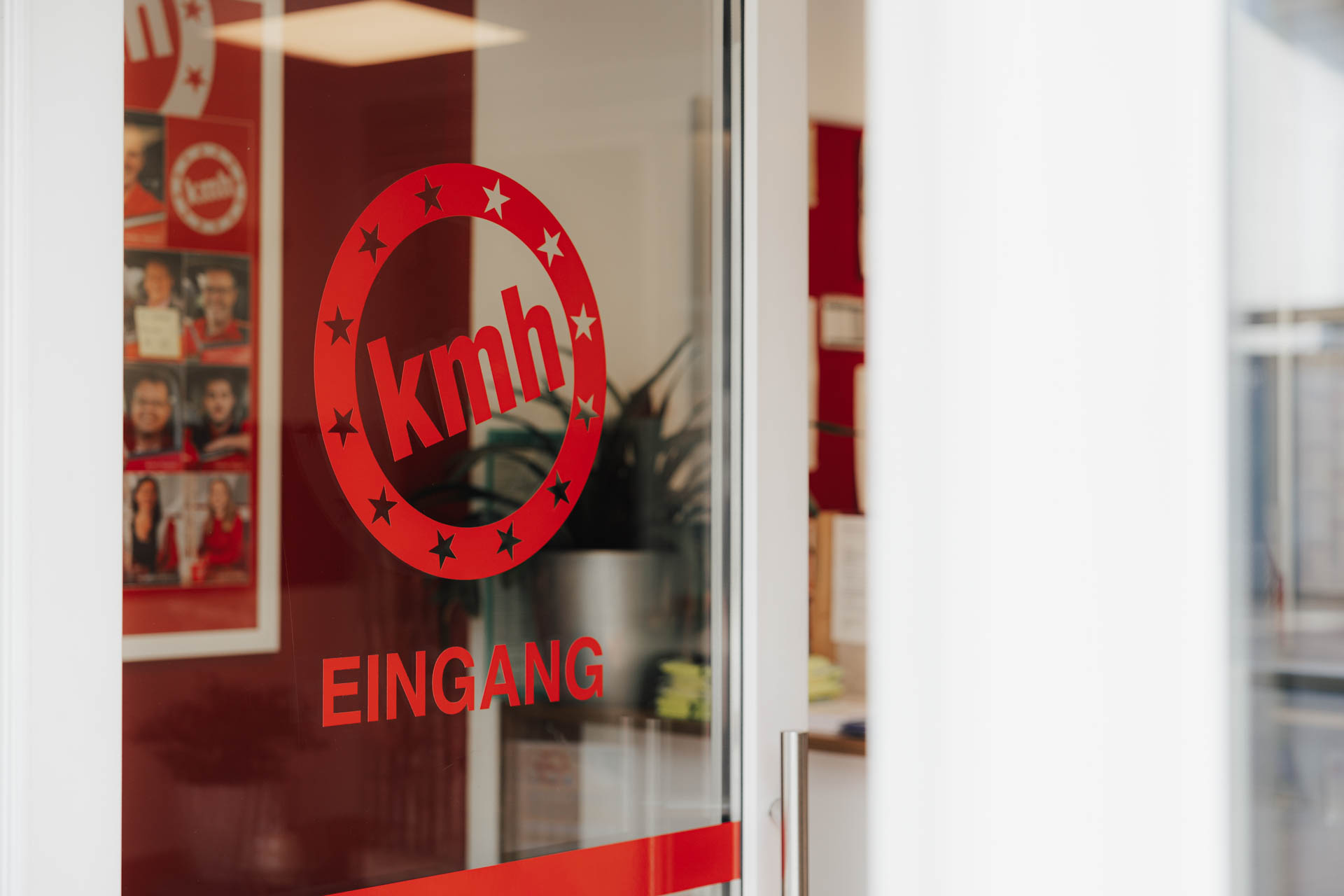 Eingangstür der fahrschule kmh mit sichtbarem Logo auf der Glastür.