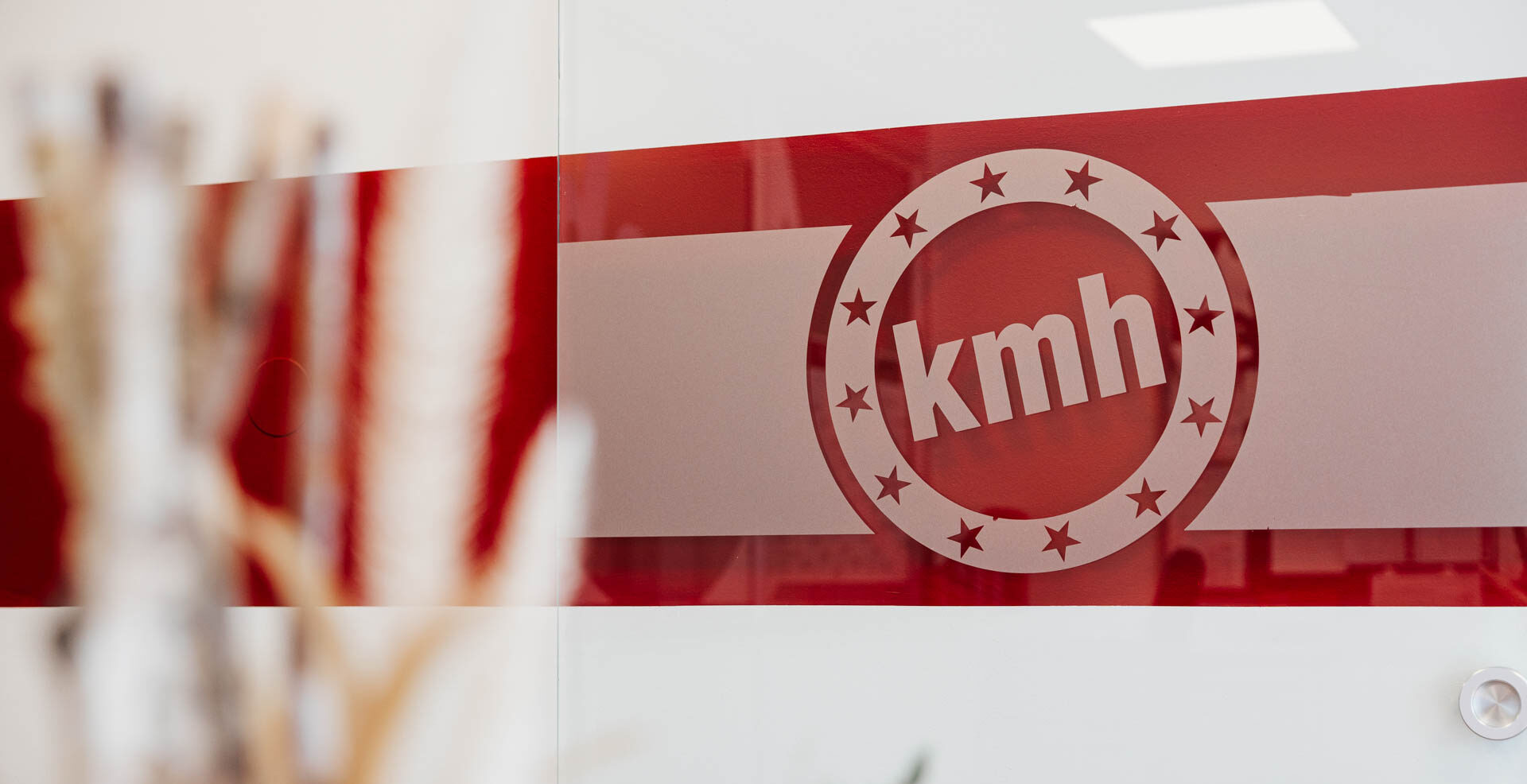 Tür im Büro der fahrschule kmh mit großer kmh Folierung.