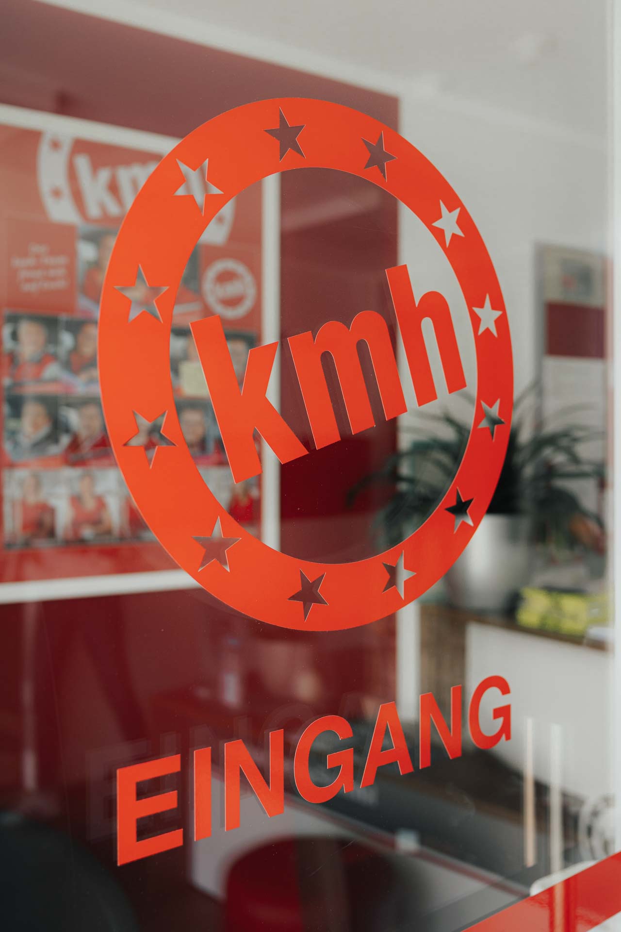 Eingangstür der fahrschule kmh mit sichtbarem Logo auf der Glastür.