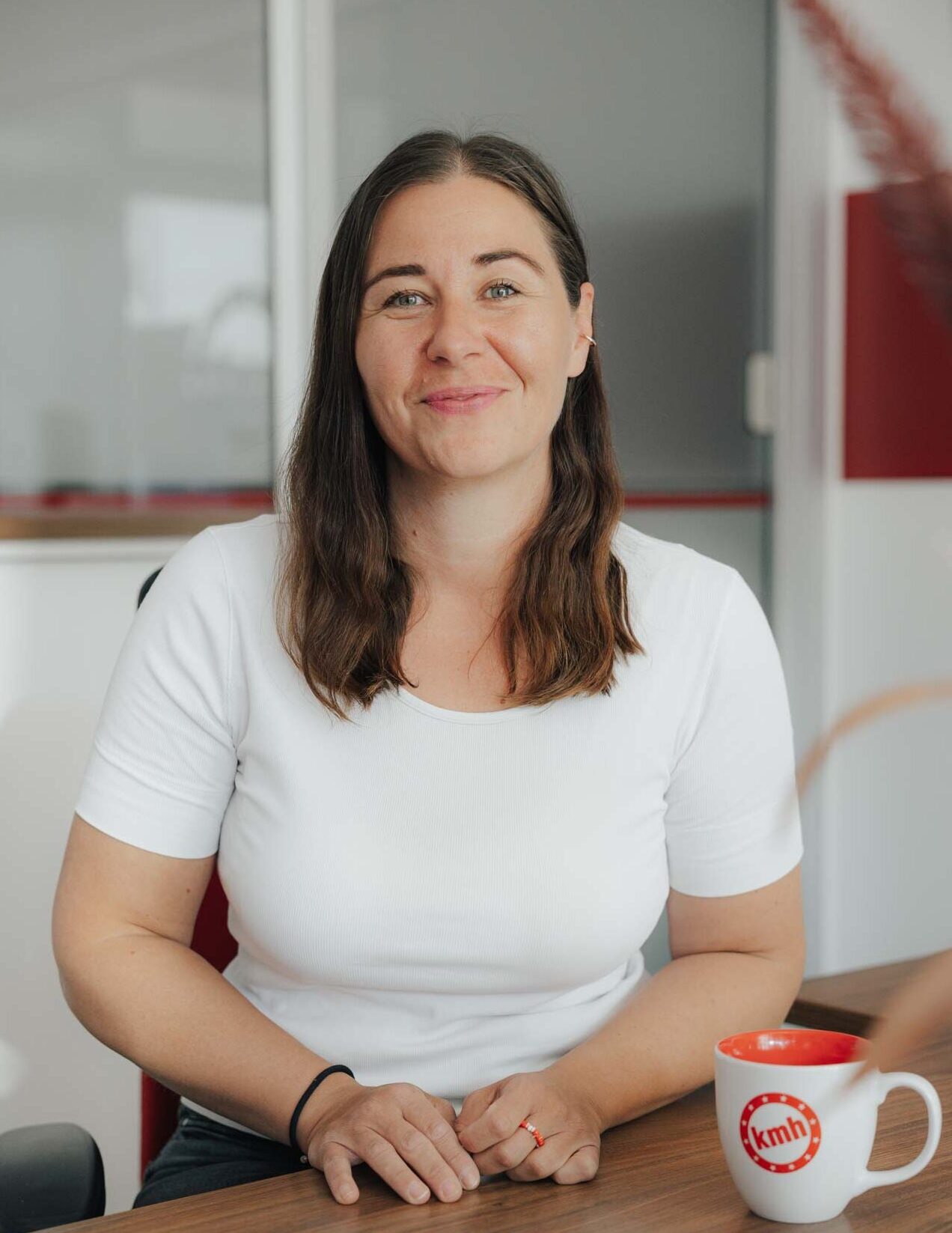 Mitarbeiterin Angelika von der Fahrschule kmh lächelnd im Büro.