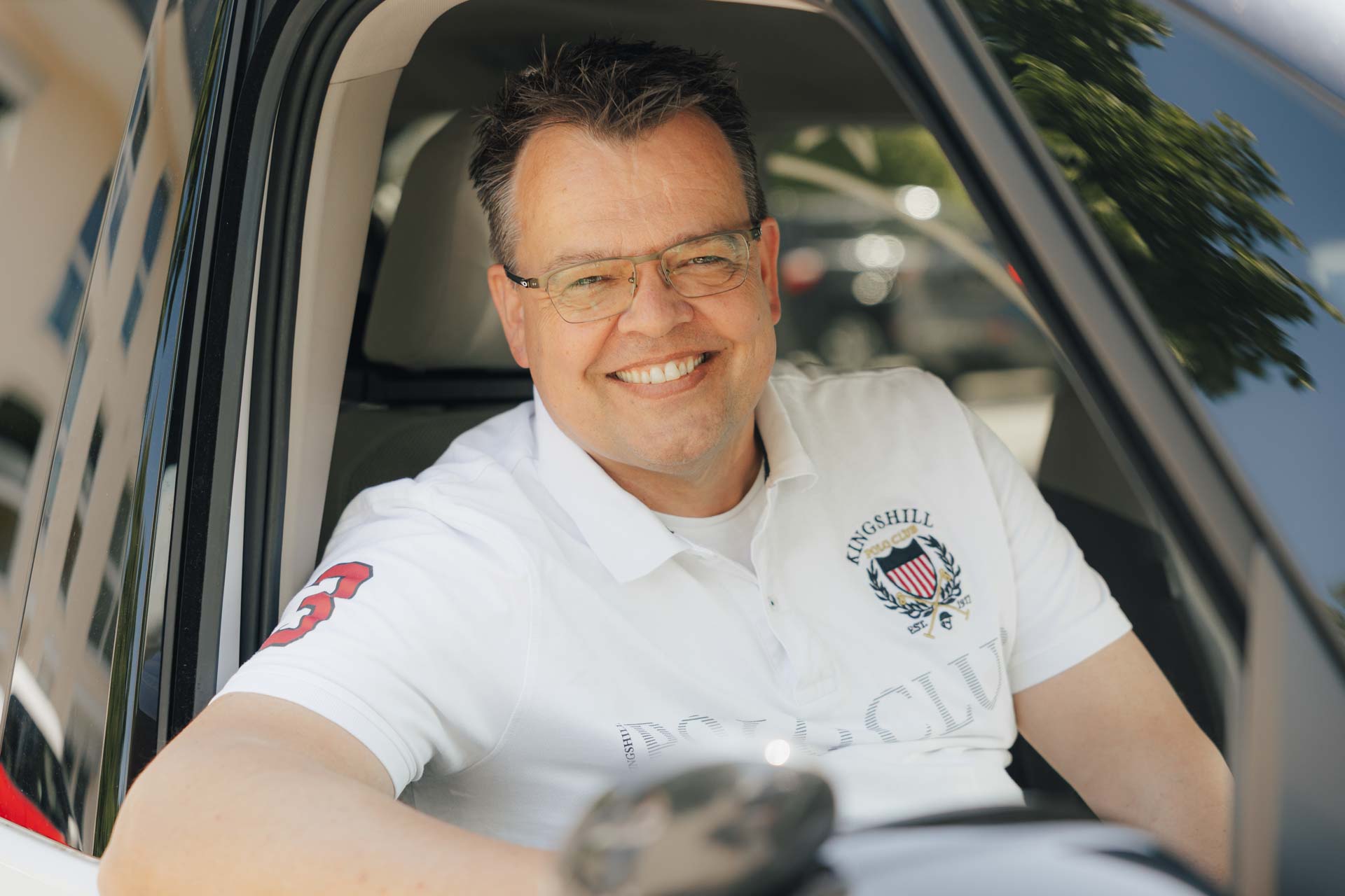 Fahrlehrer Armin von Fahrschule kmh, freundlich lächelnd, durch das Beifahrerfenster fotografiert.