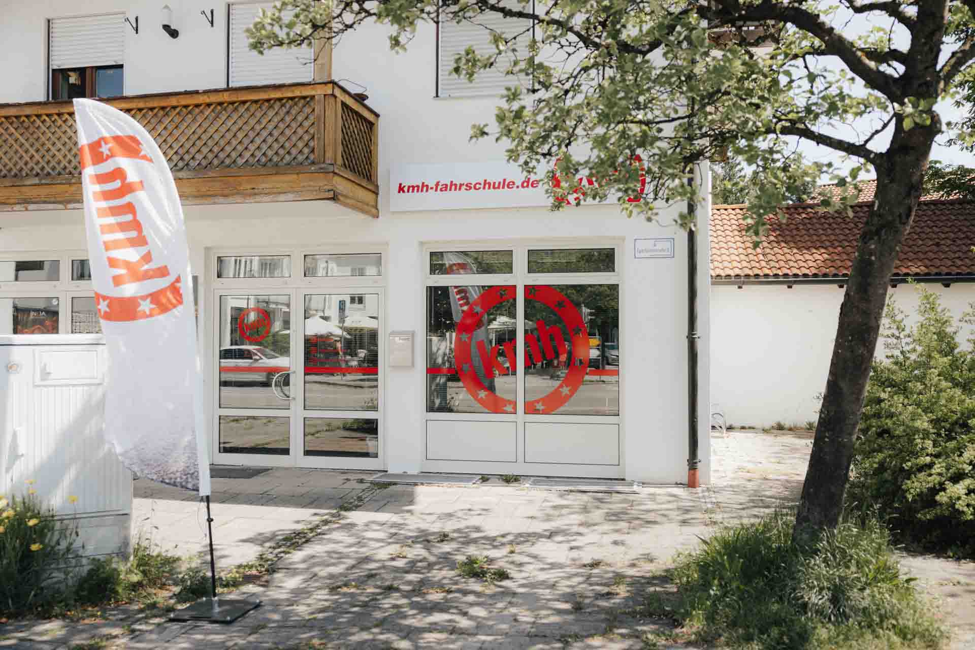 Außenansicht der kmh Fahrschule in Geretsried mit sichtbarem Fahrschul-Logo und Eingangsbereich