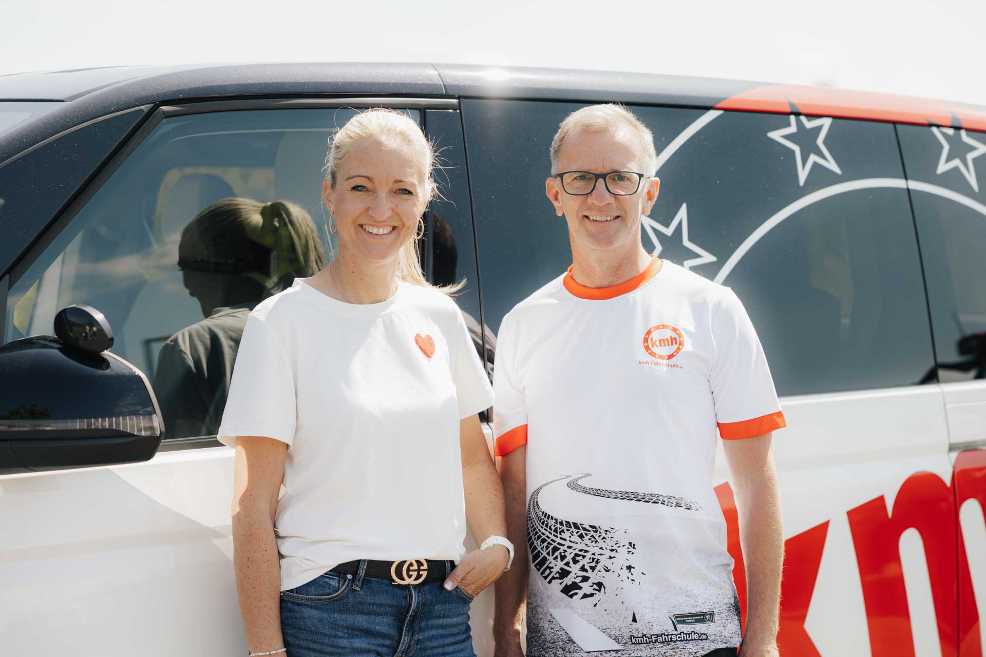 Geschäftsführung Martina Meier und Heinz Hawla vor einem Fahrschulauto der Fahrschule kmh.